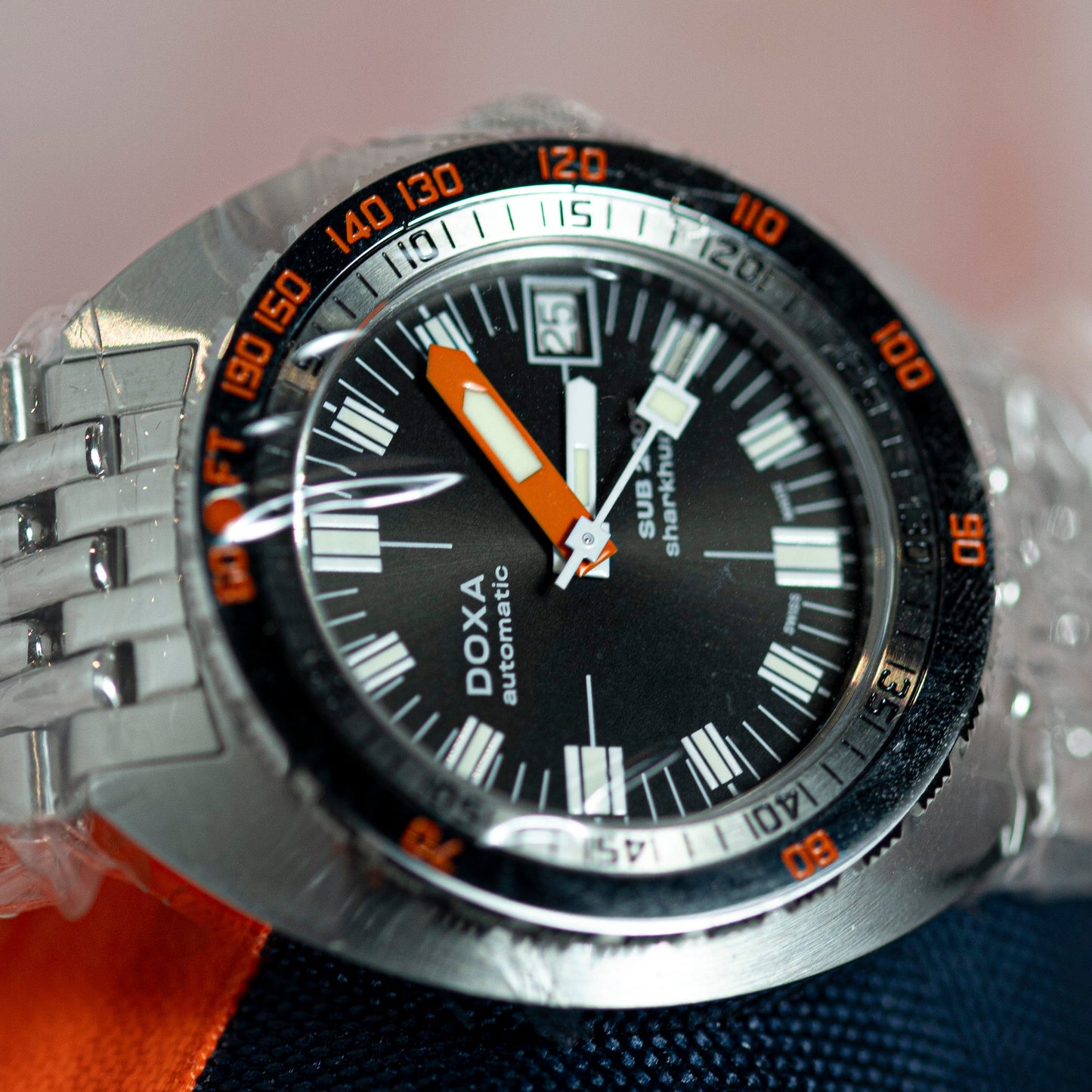 DOXA watch with a black face and silver case on a blurred background