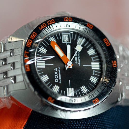 DOXA watch with a black face and silver case on a blurred background