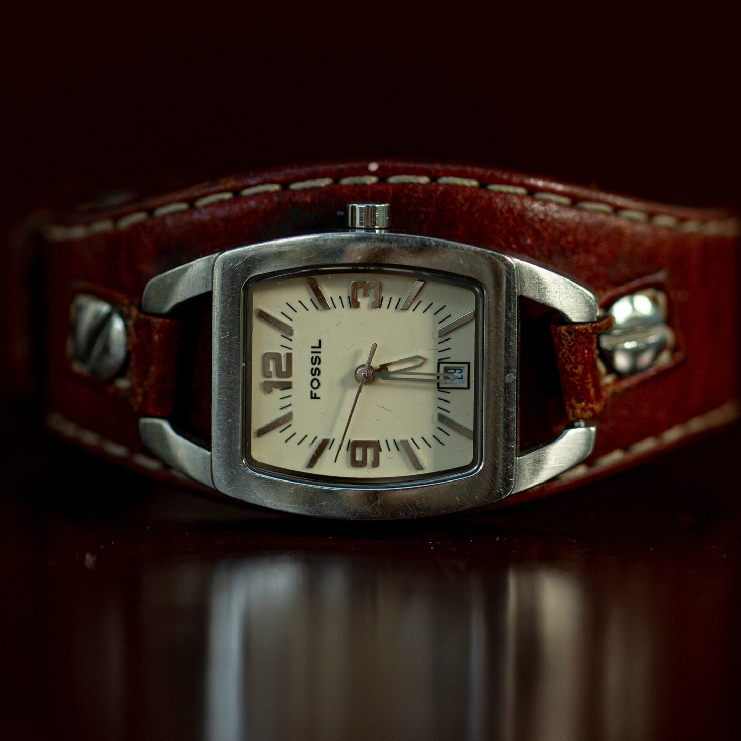 Fossil watch with brown leather strap on a dark background