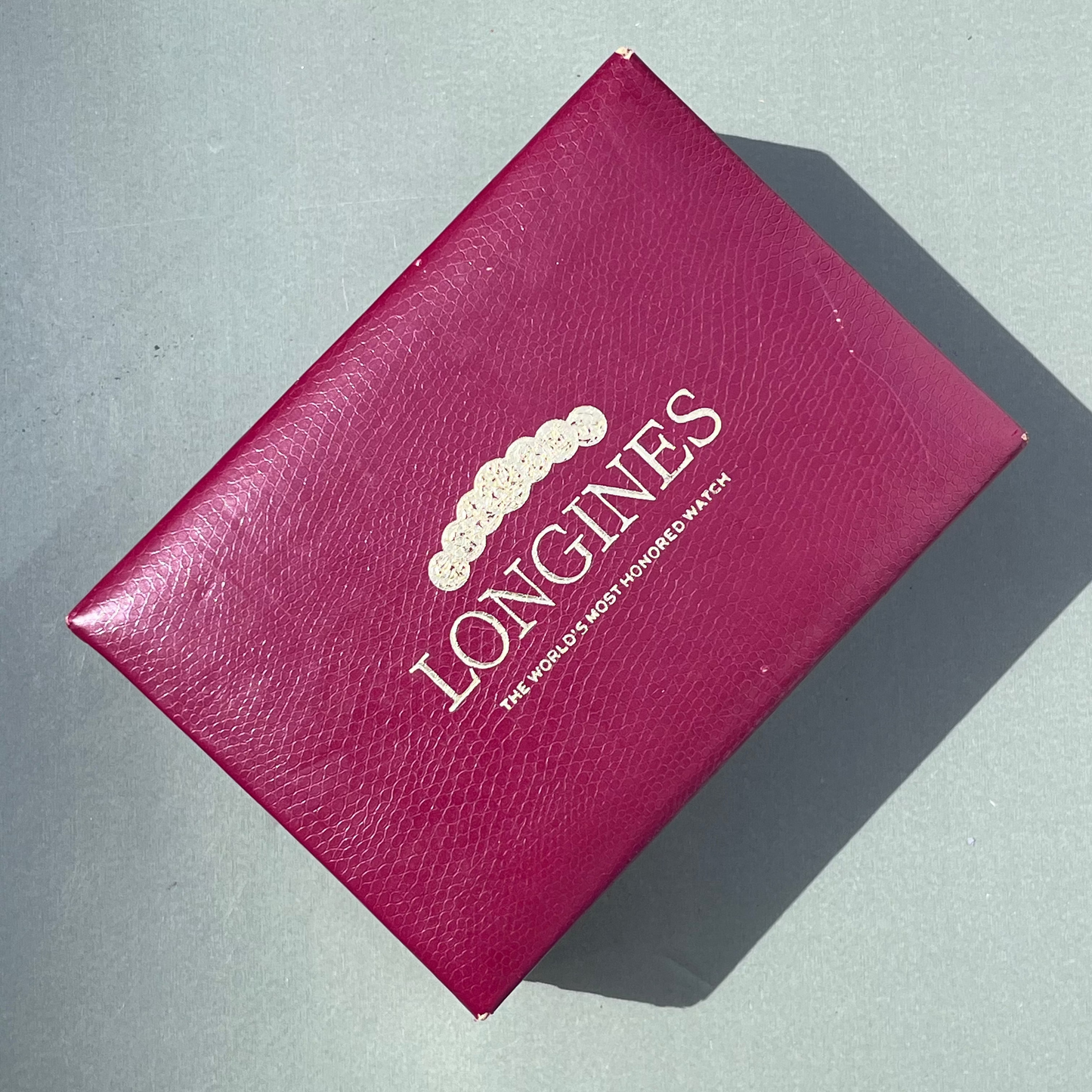 Red Longines box on a gray surface