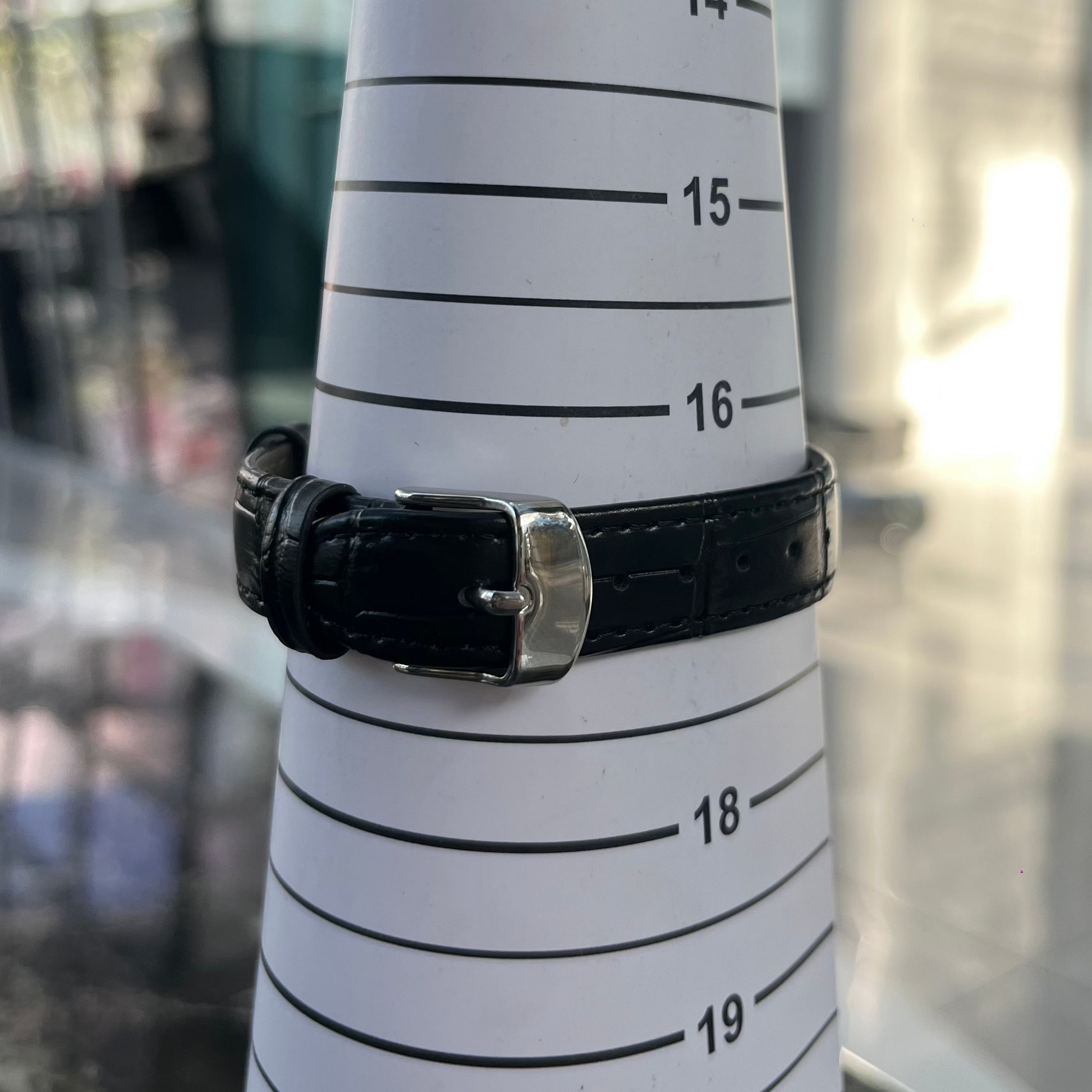 Black leather bracelet on a measuring tape with blurred background