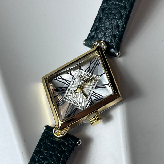 Watch with a green strap and gold case on a white background