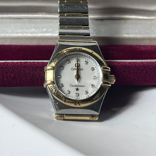 Vintage watch with a gold and silver band on a white background