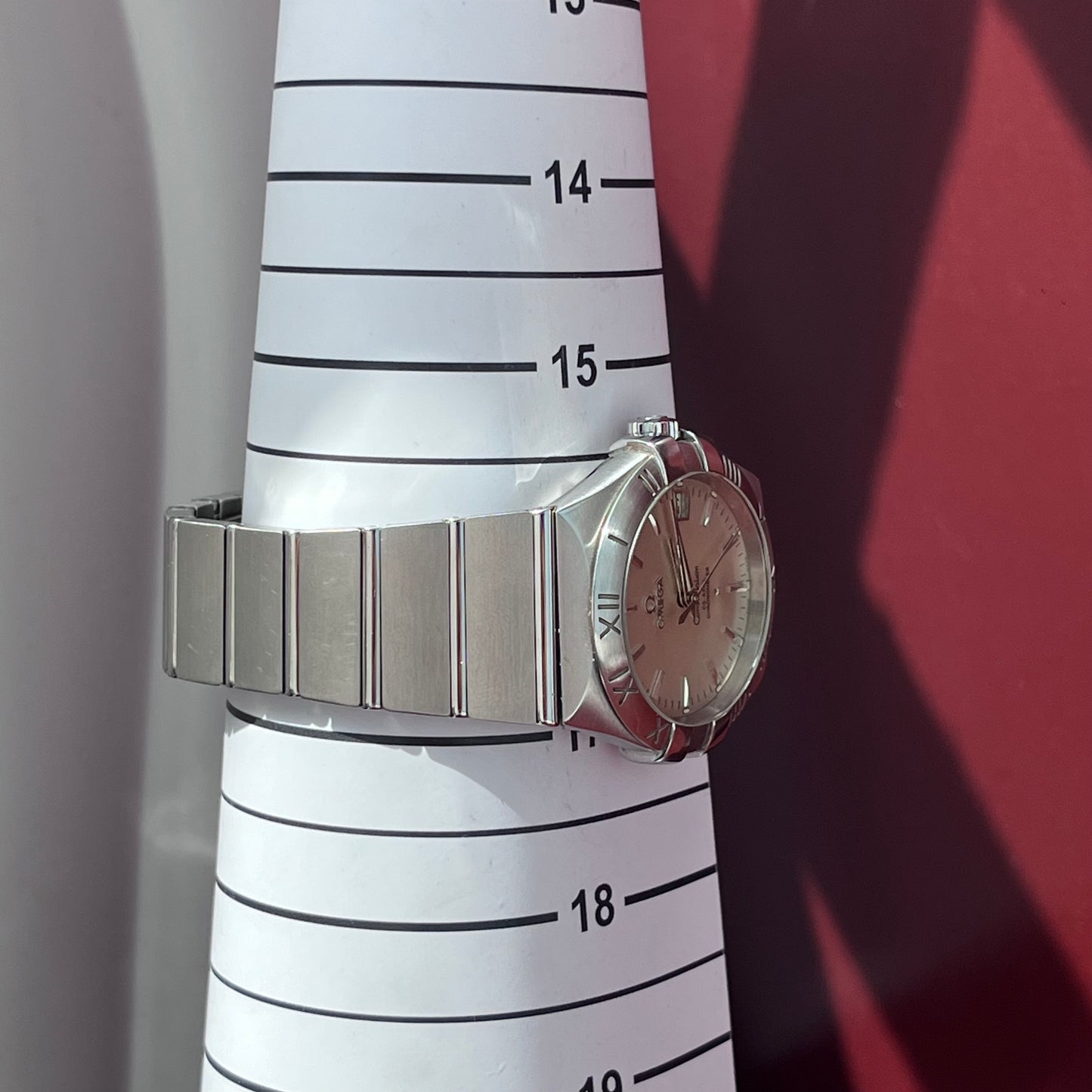 Silver watch on a white measuring tape with black markings