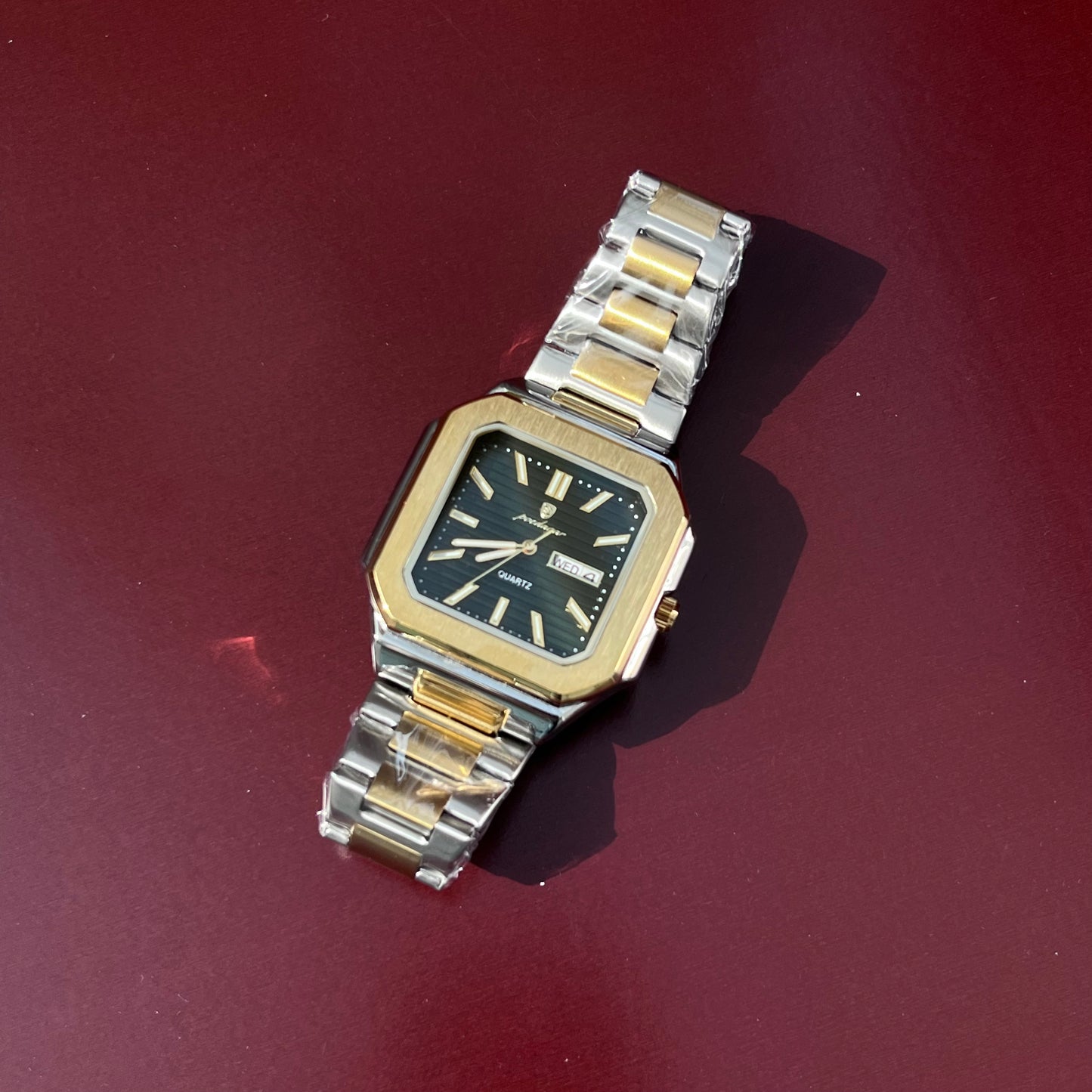 Vintage watch with a silver and gold band on a red background
