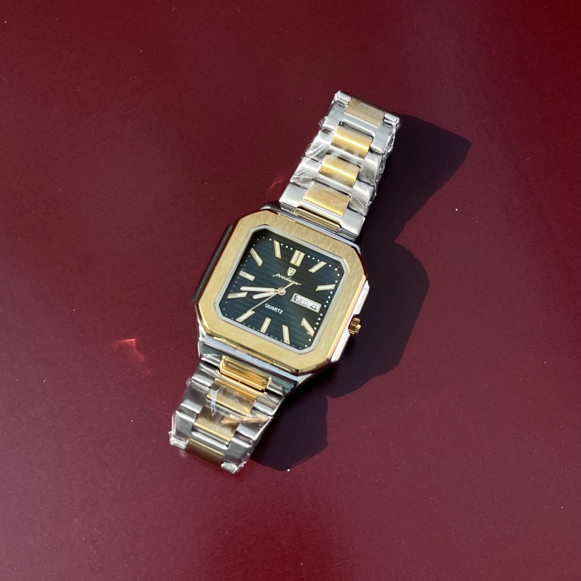 Vintage watch with a silver and gold band on a red background