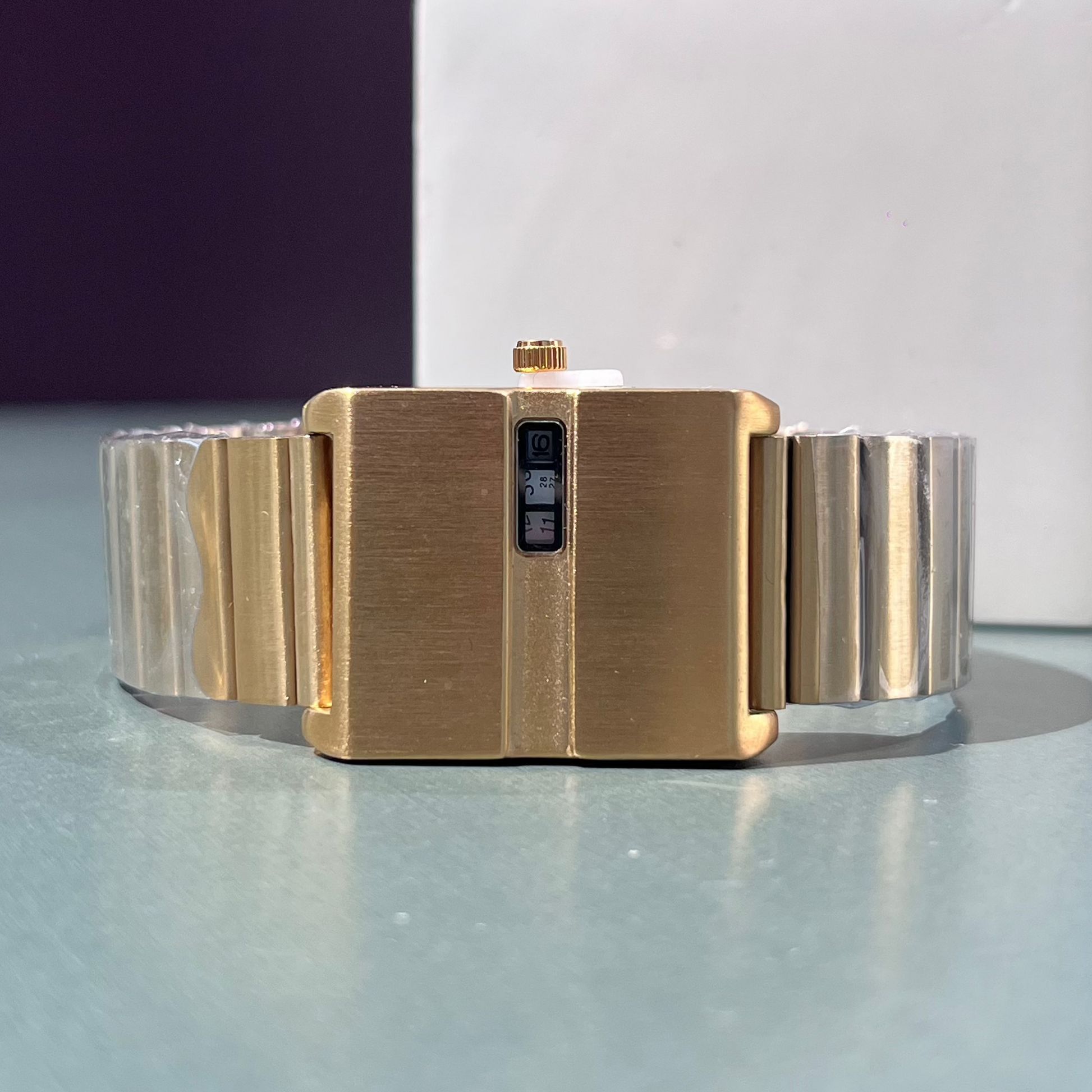 Gold bracelet on a reflective surface with a blurred background