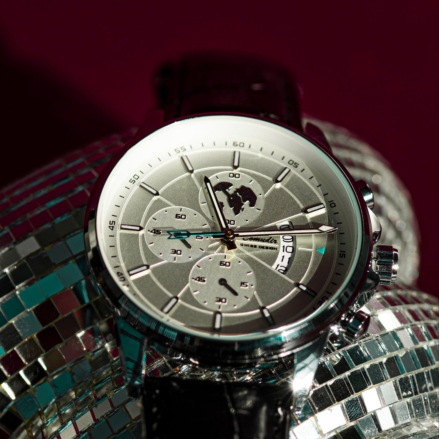 Silver watch on a disco ball with a dark background