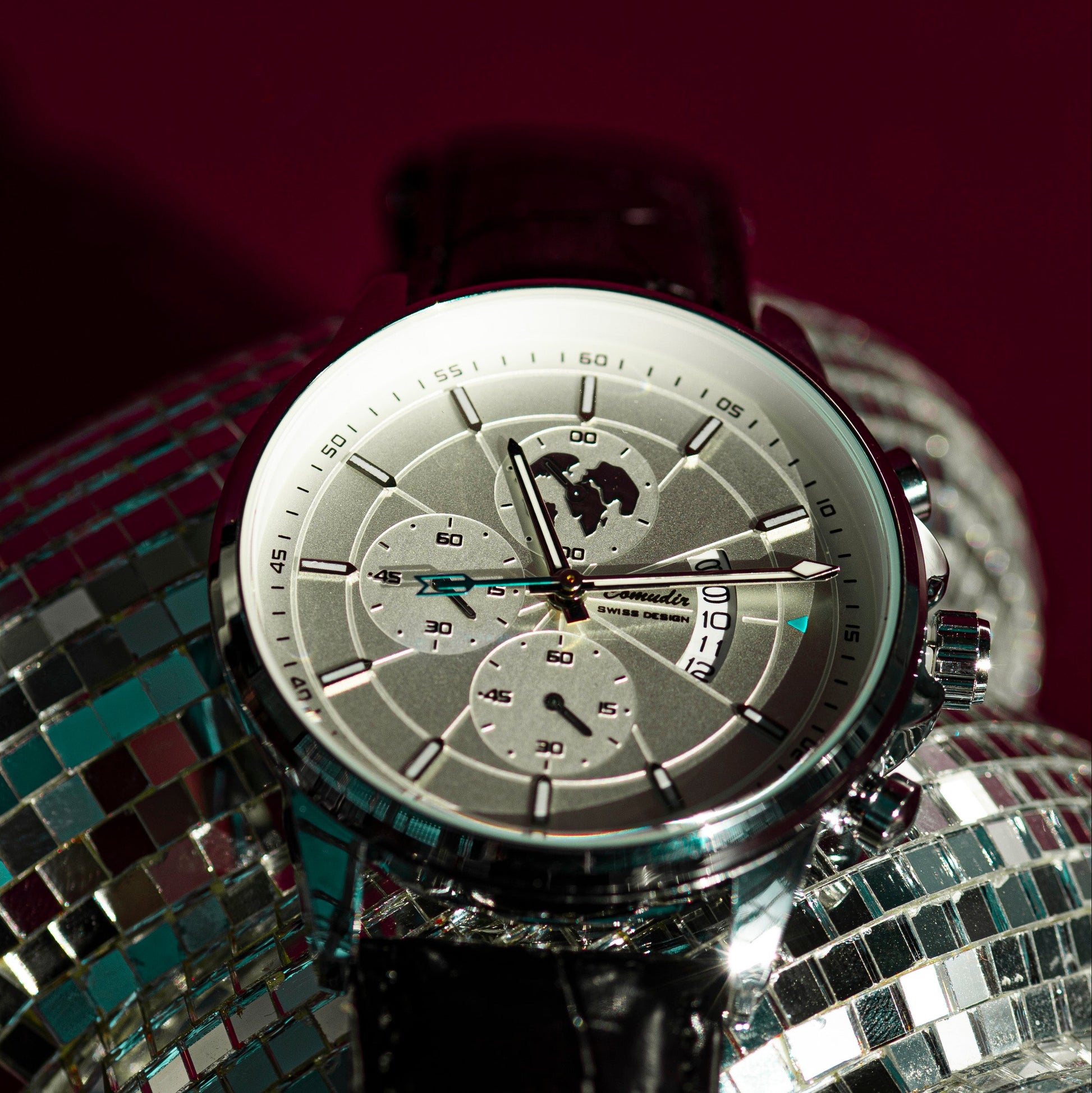 Silver watch on a disco ball with a dark background