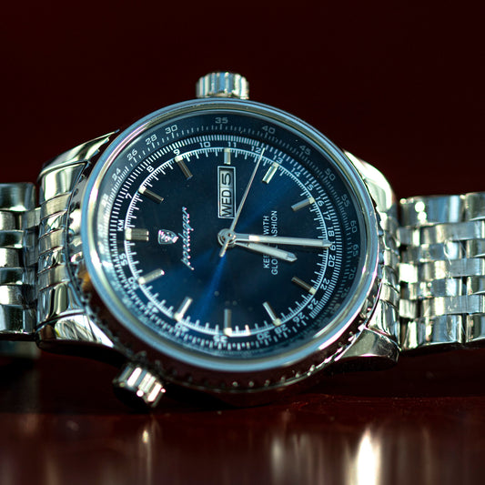 Silver watch with a blue face on a dark background
