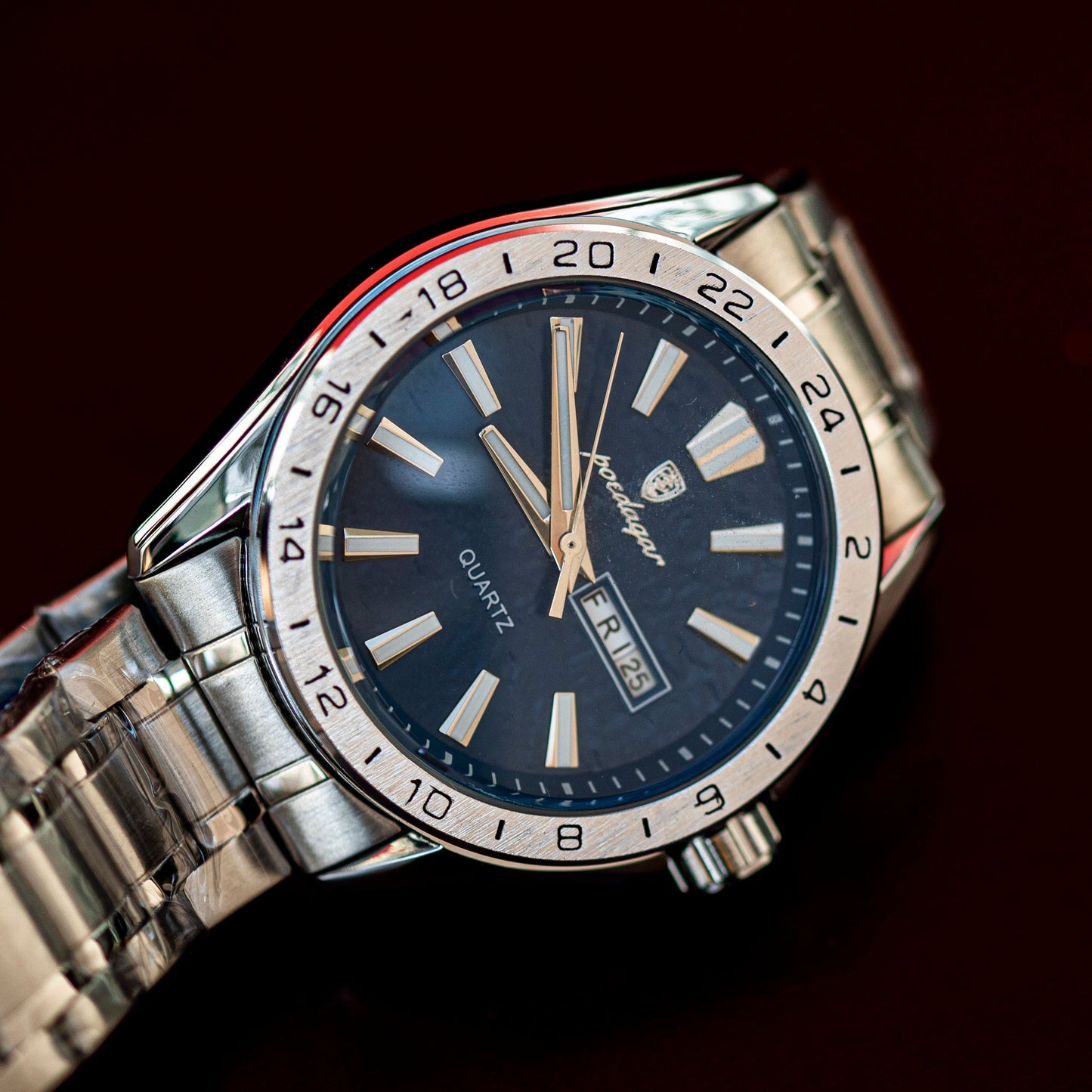 Silver wristwatch with a blue dial on a dark background