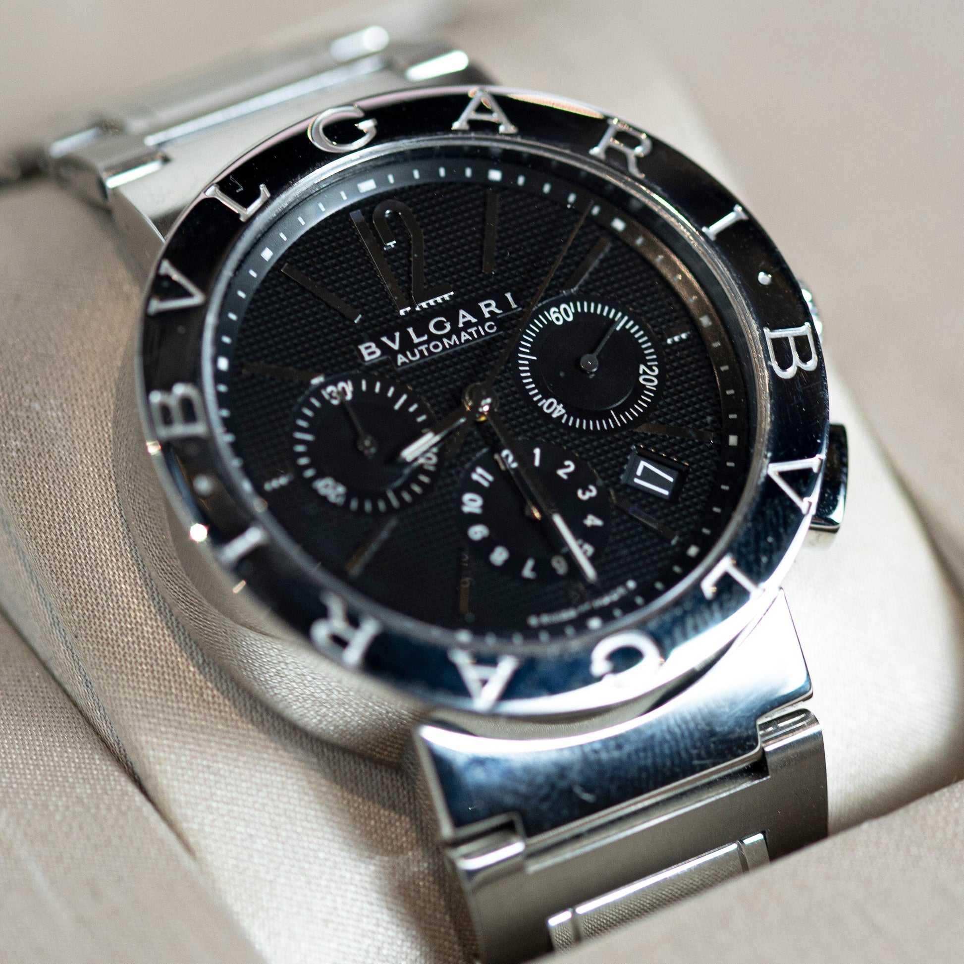 Bulgari watch with black dial and silver case on a light gray background