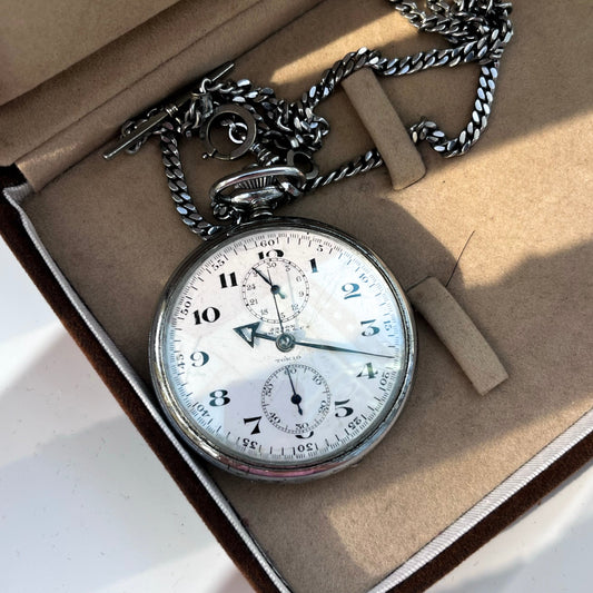 Vintage pocket watch with chain in an open box on a light background