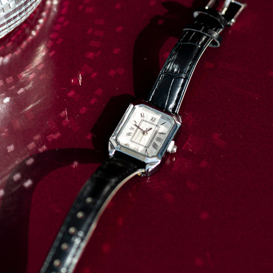Wristwatch with black strap on a red background